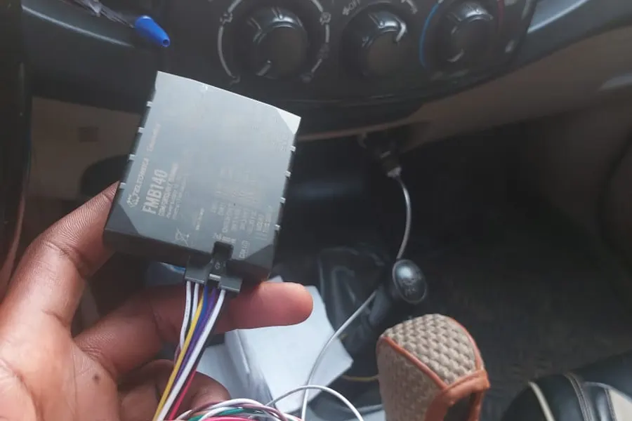 Balise GPS Teltonika FMB140 tenue en main avant sa pose dans un véhicule